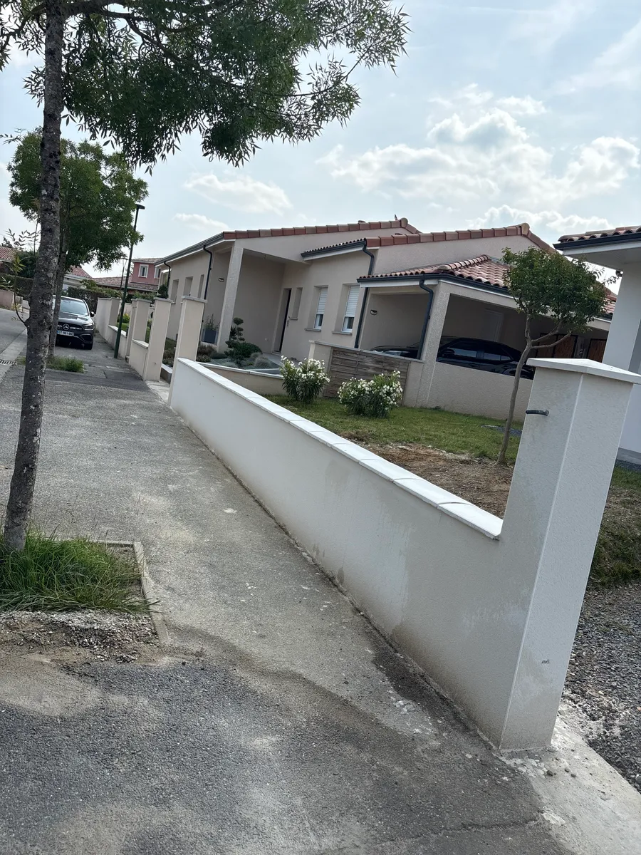 Maison et aménagement extérieur réalisés par ENT. Claveria : mur en maçonnerie, chemin pavé et plantations